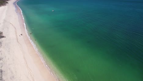 4K-Aerial-Drone-Flight-Over-Turquoise-Blue-Clear-Ocean-Water-And-White-Sand-At-Conchal-Beach,-Costa-Rica