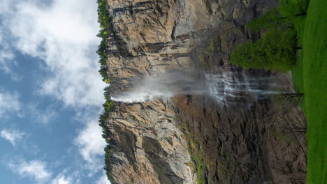 Vertikaler-4K-Zeitraffer,-Wasserfall-In-Den-Schweizer-Alpen,-Wolken-Und-Grüne-Landschaft-Im-Frühling