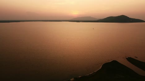 Atemberaubender-Sonnenuntergang-über-Den-Thailändischen-Bergen.-Luftaufnahme-Der-Ruhigen-Wasseroberfläche-Und-Des-Orangefarbenen-Scheins
