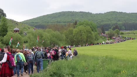 Huge-crowd-of-people-walk-winding-path-up-hillside-while-on-Csiksomlyo-Pilgrimage