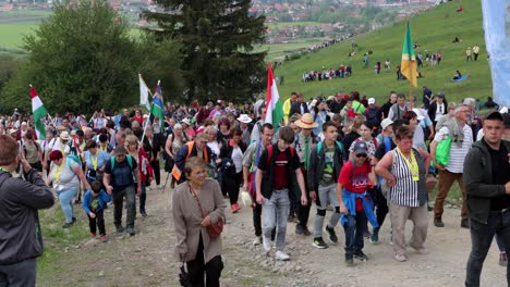 Multi-generational-crowd-walk-uphill-towards-camera-on-Csiksomlyo-Pilgrimage