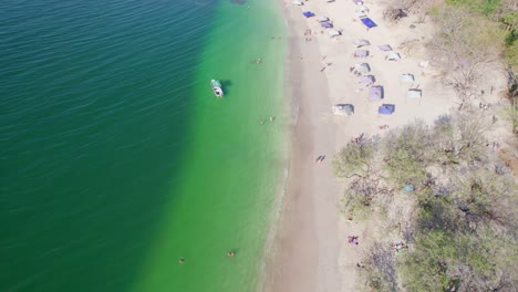 Aerial-Drone-4K-View-Over-People-On-Conchal-Beach-And-Boat-In-Blue-Ocean,-Costa-Rica
