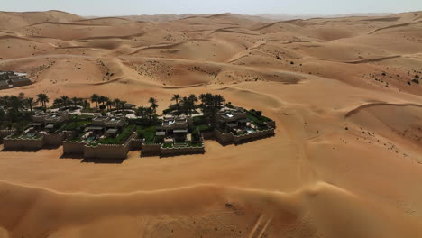 Disparo-De-Drones-Inclinándose-Sobre-Un-Resort-Oasis-En-El-Desierto-En-Un-Día-Soleado-En-Los-Emiratos-Árabes-Unidos