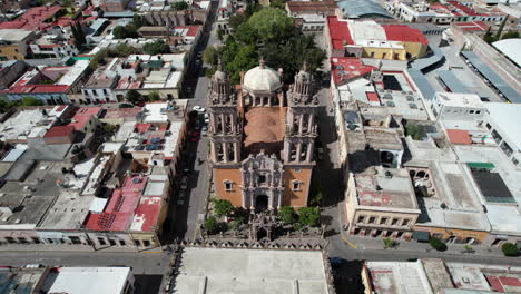 Aerial-drone-footage-advancing-towards-the-Sanctuary-in-Jerez,-Zacatecas,-camera-tilts-down-to-a-full-cenital-view-over-the-bell-towers