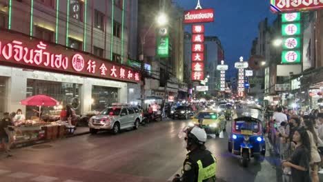 Policía-Vigilando-El-Tráfico-En-Chinatown-Por-La-Noche-Con-Luces-Iluminadas-En-Bangkok,-Tailandia