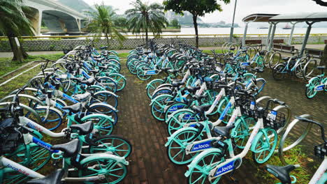 Bicicletas-De-La-Ciudad-De-Hong-Kong-En-Movimiento:-Toma-De-Cardán-En-Cámara-Lenta-De-Una-Flota-Estacionada-De-Bicicletas-Compartidas
