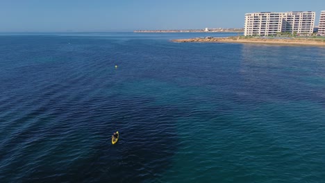 Aerial-view-of-kayak-fishing-at-seascape,-trolling-fishing-drone-view