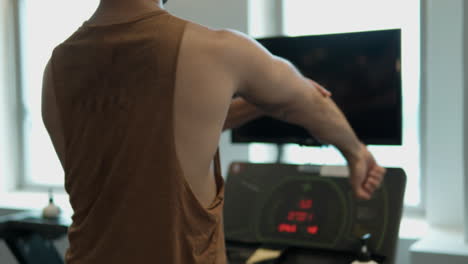 Unrecognizable-Man-Walking-on-Treadmill-in-Health-Centre-and-Warming-Up-Arms-and-Elbow-Joints,-Stretch-Muscles-Preparing-For-Workout---close-up-slow-motion