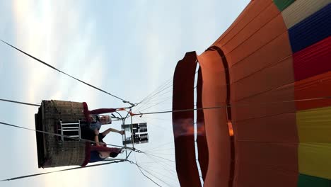 Vertical-Static-slow-motion-shot-of-a-large-colorful-hot-air-balloon-for-a-balloon-ride-on-bali-in-indonesia-during-an-adventurous-journey-through-the-air-with-passengers-enjoying-the-view