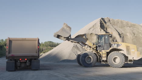 Daylight-Quarry-Operations-with-Front-Loader-Unloading-Sand-Into-Dump-Truck-Container