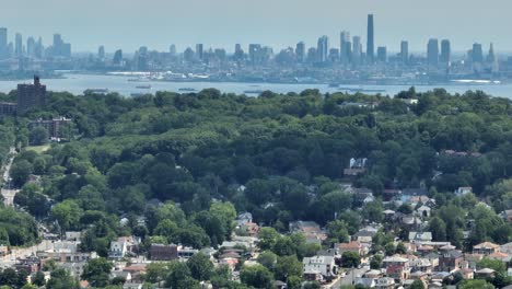 Panorama-Drohnenaufnahme-Eines-Vorortbezirks-Auf-Staten-Island-Und-Der-Riesigen-Skyline-Von-Manhattan-An-Einem-Nebligen-Tag-Im-Hintergrund---Luftaufnahme-Mit-Zoomobjektiv
