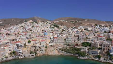 Aerial:-Slow-panoramic-drone-panning-shot-of-Ermoupoli-in-Syros-island,-Greece-on-a-sunny-day