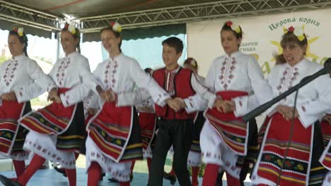 Felices-Artistas-Sonrientes-Con-Trajes-Tradicionales-Bailando-Horo-Búlgaro-En-El-Escenario