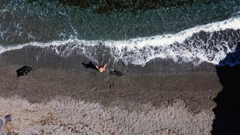 People-at-the-beach-aerial-drone-view-playing-beach-tennis,-sunbathing,-enjoy-holidays-at-the-seashore