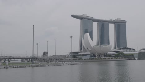 Halten-Sie-Die-Beeindruckende-Skyline-Von-Singapur-An-Einem-Bewölkten-Tag-Mit-Wasser-Im-Vordergrund-Fest