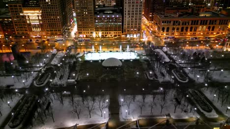 Chicago-IL-USA-at-Winter-Night,-Drone-Shot-of-The-Bean-Sculpture-and-Ice-Skating-Rink-in-Millennium-Park-and-Traffic-on-Michigan-Avenue
