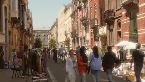 Gente-Caminando-Por-La-Calle-Con-Un-Mercadillo-Que-Vende-Artículos-De-Segunda-Mano-En-Ixelles,-Bruselas,-Bélgica