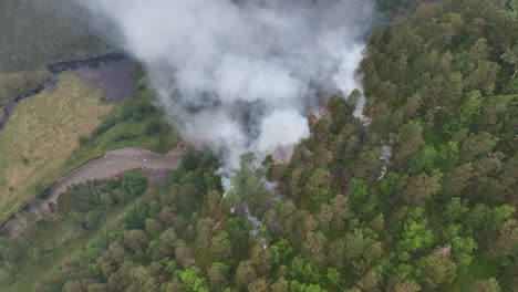 Forest-fire-started-by-lightning-burning-above-river-valley-in-Stamnes-Norway---Aerial