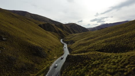 Aerial-tracking-shot-of-a-convoy-of-trucks-driving-through-picturesque-New-Zealand
