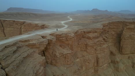 Person-standing-on-cliff-edge-at-Edge-Of-The-World-in-Saudi-Arabia
