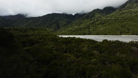 Fpv-Acrobático-Que-Revela-La-Toma-De-Un-Arroyo-Que-Corre-En-El-Valle-De-La-Montaña-En-Nueva-Zelanda