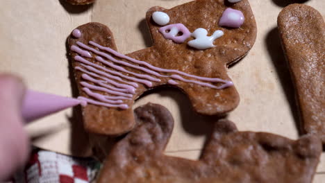 Pink-glazing-applied-on-gingerbread-cat-cookie