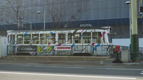 Weiße,-Farbenfrohe-Sapporo-Straßenbahn,-Die-Auf-Die-Abfahrt-Wartet