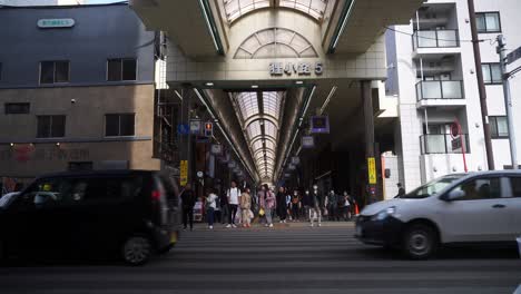Gente-Esperando-En-El-Cruce-Con-El-Tráfico-Que-Pasa-Fuera-Del-Centro-Comercial-Tanukikoji-En-Sapporo.