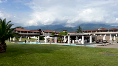 Dion-Palace-Resort-and-Spa-against-the-backdrop-of-Mount-Olympus,-the-highest-mountain-in-Greece,-shrouded-in-big-white-clouds