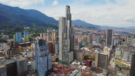 Torres-Altas-Y-Modernas-Rodeadas-De-Edificios-Más-Bajos-En-El-Centro-Con-Una-Cordillera-Al-Fondo