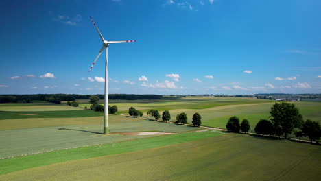 Wind-farm-on-the-green-field-against-a-blue-sky---aerial-high-angle-view