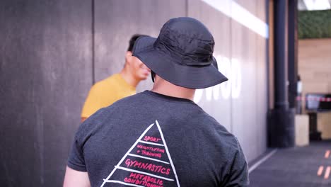 Smiling-muscular-man-with-a-fishers-hat,-attempting-an-open-gym-event