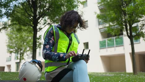 Female-engineer-works-outdoors-setting-parameters-for-photogrammetry-on-remote-control-of-drone