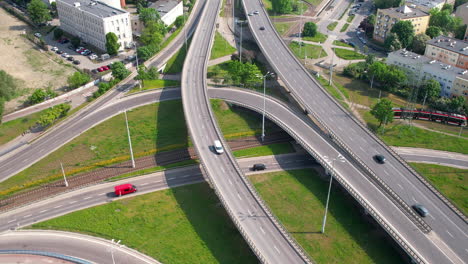 Gdansk-Wezel-Kliniczna-large-curved-highway-interchange-with-multiple-connecting-roads-and-cars-traffic-on-summer-day---aerial-revealing