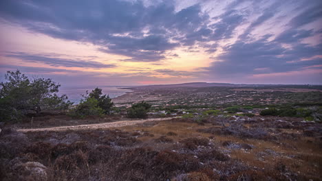 The-panorama-of-the-beach-and-coastline,-accompanied-by-the-captivating-spectacle-of-clouds-meeting-on-the-horizon-during-the-sunset,-presents-an-enthralling-observation-in-Ayia-Napa,-Cyprus