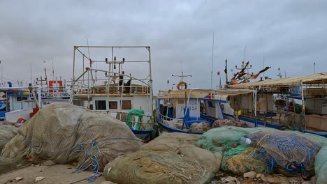 Djerba-harbor-with-fishing-boats,-nets-and-fishermen