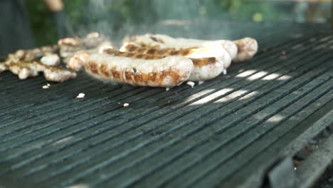 Der-Koch-Kocht-Würstchen-Und-Schweinefleisch-Beim-Festival-Grill-Auf-Einer-Heißen,-Rauchigen-Bratpfanne