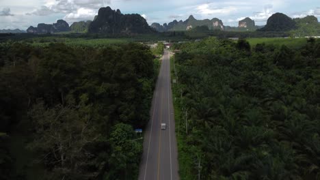 Aerial-of-car-road-with-the-sharp-rocky-mountainous-hills-of-Krabi-district
