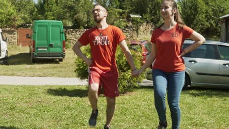 Energetic-happy-young-couple-dancing-lively-to-music-at-folklore-festival