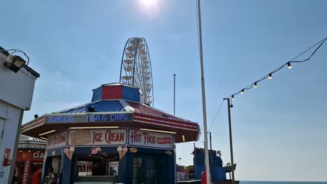 Walking-towards-Blackpool-promenade-seaside-Ferris-wheel-passing-ice-cream-kiosk