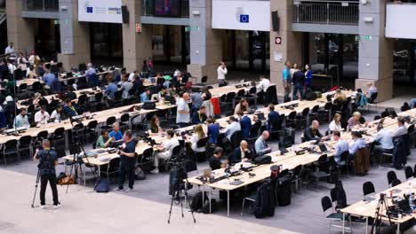 Journalists-working-in-the-press-room-of-the-Justus-Lipsius-building-during-the-European-Council-summit-in-Brussels,-Belgium---Panning-shot