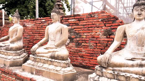 Parque-Nacional-Histórico-De-Ayutthaya-En-Tailandia-Con-Estatuas-Budistas-Tailandesas-A-Lo-Largo-De-Una-Pared-De-Ladrillo-Rojo