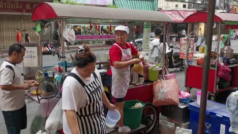 Thai-Street-Food-Vendors-Cooking-and-Preparing-Food-in-Chinatown,-Bangkok,-Thailand