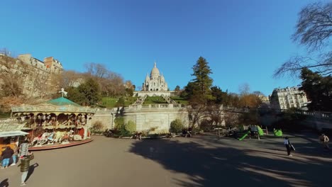 Ground-level-rising-to-reveal-Sacre-Coeur,-Montmartre-midday-from-park-below