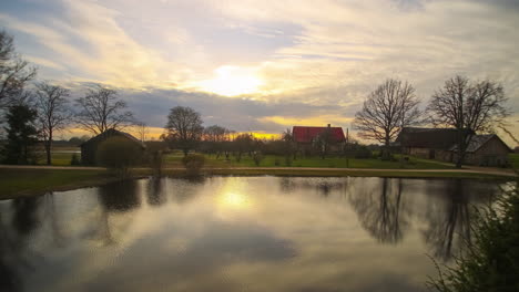 Beautiful-timelapse-view-of-a-farm-beginning-at-sunrise,-cloud-cover-rolls-in,-the-sun-appears-and-concludes-at-sunset-with-a-magnificent-color-display-and-twilight-sets-in