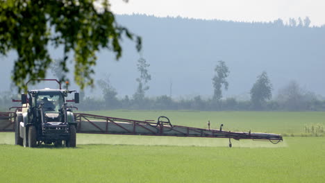 Agricultor-Con-Tractor-Pulverizador-Pulverizando-Cultivos-Con-Brazo-Ancho,-Hedemora,-Suecia