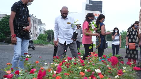 Vista-Frontal-De-Un-Hombre-Comprando-Plántulas-De-Rosas-Amarillas-Y-Muchas-Mujeres-Comprando-Coloridos-Injertos-De-Rosas-Para-Plantar-En-Sus-Huertos