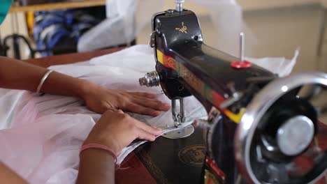 close-up-scene-in-which-an-Indian-woman-is-operating-a-very-fine-sewing-machine-at-high-speed-due-to-her-skill-and-extensive-experience