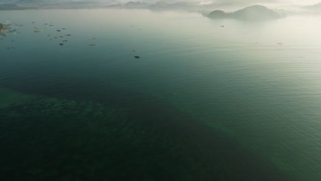 Mist-rising-over-Gerepuk-bay-on-scenic-sunrise,-Lombok-island,-Indonesia,-aerial