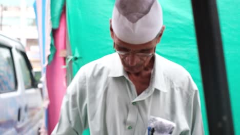 A-senior-citizen-is-distributing-chickpea-stands-for-birds-at-a-concessional-rate-at-the-street-market